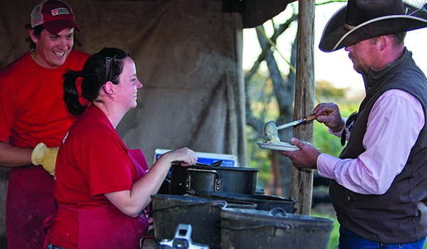 Tom and Bridget serve the meal we prepared to one of the guests. Sharing food with friends is what cooking is all about.
