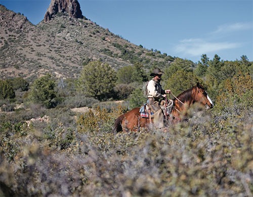 A person rides a horse on the Spider Ranch.