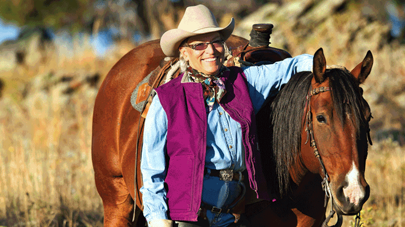 Connie Weishaar standing in field with horse