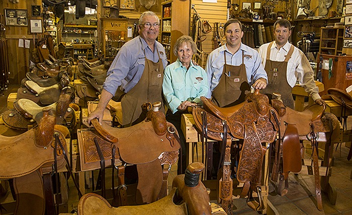 Richard Oliver and family standing by saddles