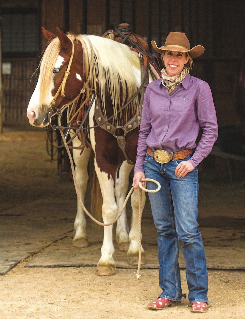 Kellie Neubert standing with paint horse