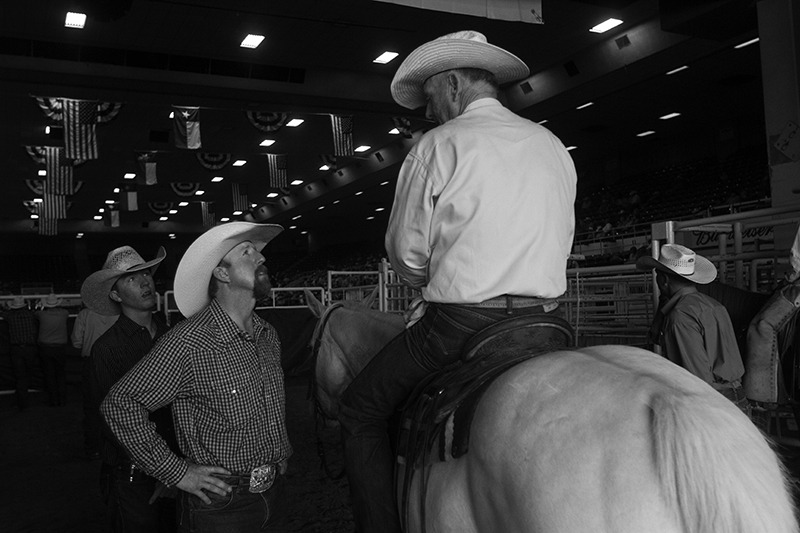 Cowboys visiting about a horse.