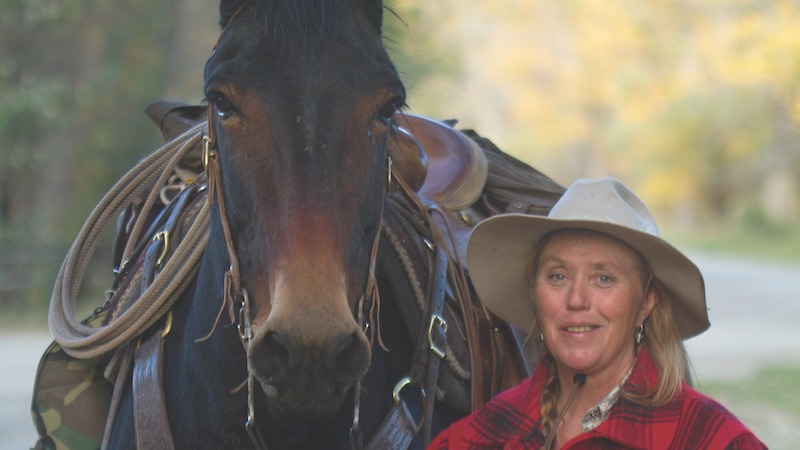 Wanda Wilcox standing by a mule