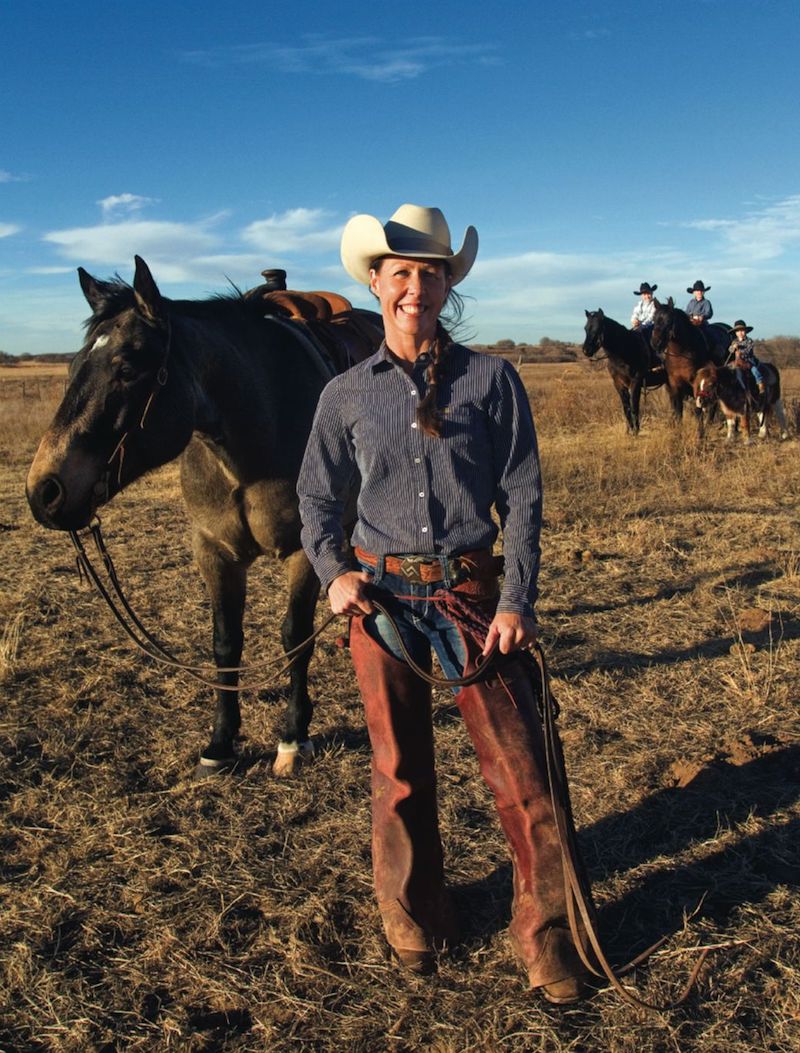 Lori Campbell standing by horse with family in background