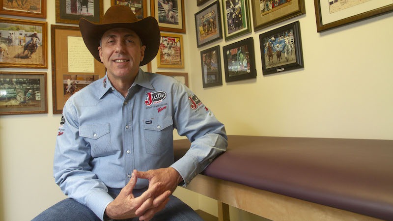 Tandy Freeman sitting in office with rodeo images in the background