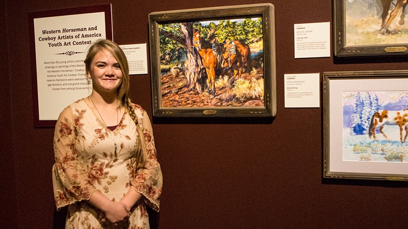 youth art contest winner standing by painting