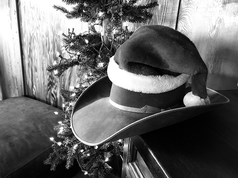 cowboy hat with santa hat on top