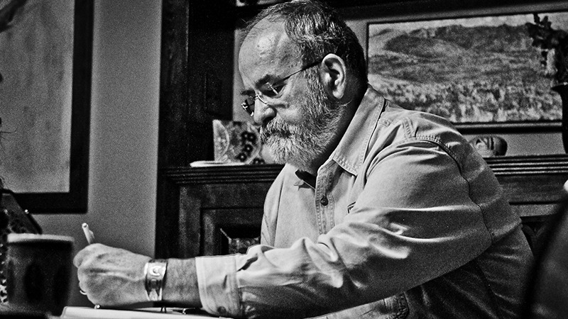 Hal Cannon sitting at desk writing