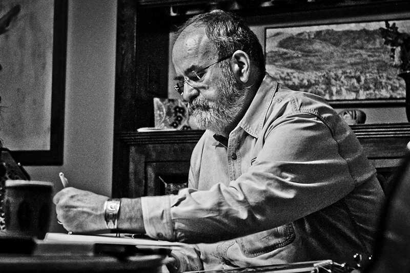 Hal Cannon sitting at desk writing