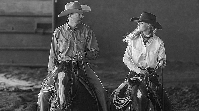 husband and wife riding horses next to each other