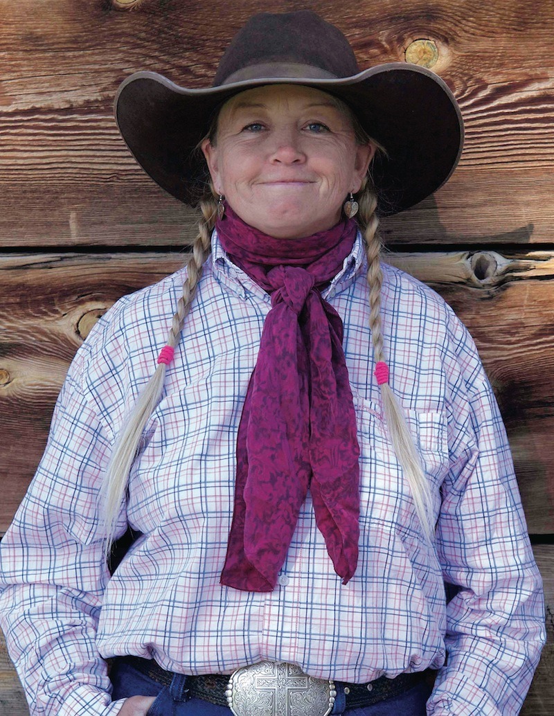 Sheila Carlson standing in front of wooden wall