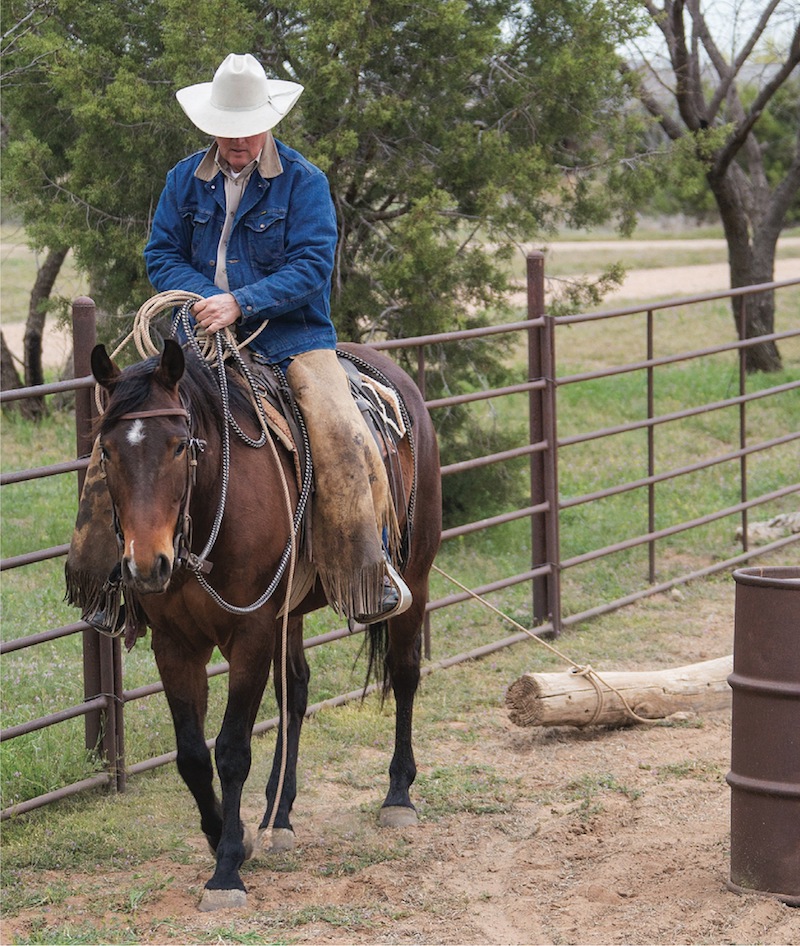 Joe Wolter taking green horse between fence and barrel