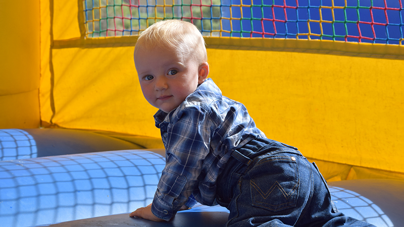 baby boy in bounce house at rodeo