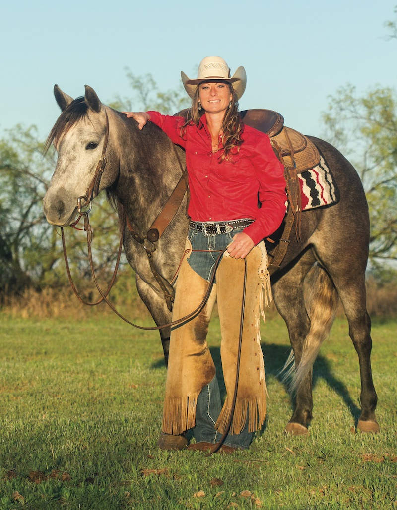 Tiffany McLaury standing in the pasture with her horse