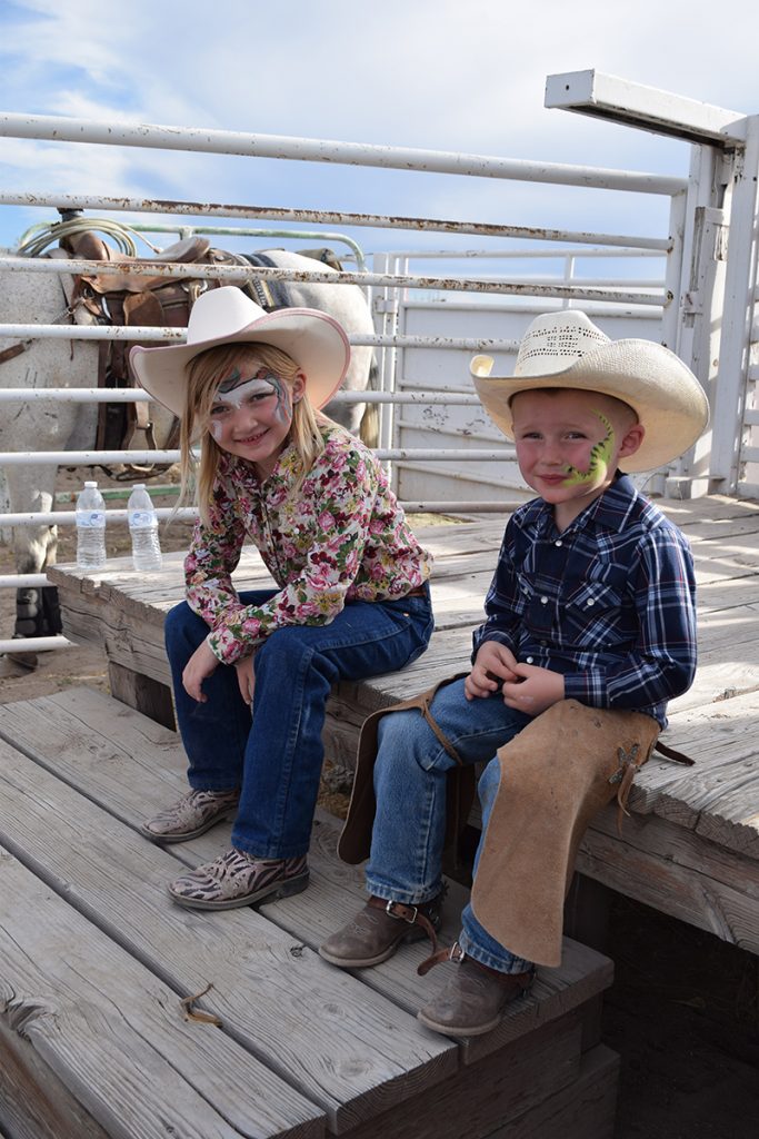 cowboy and cowgirl with faces painted at the rodeo 