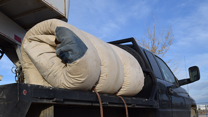 rolled bedroll on a flatbed pickup truck