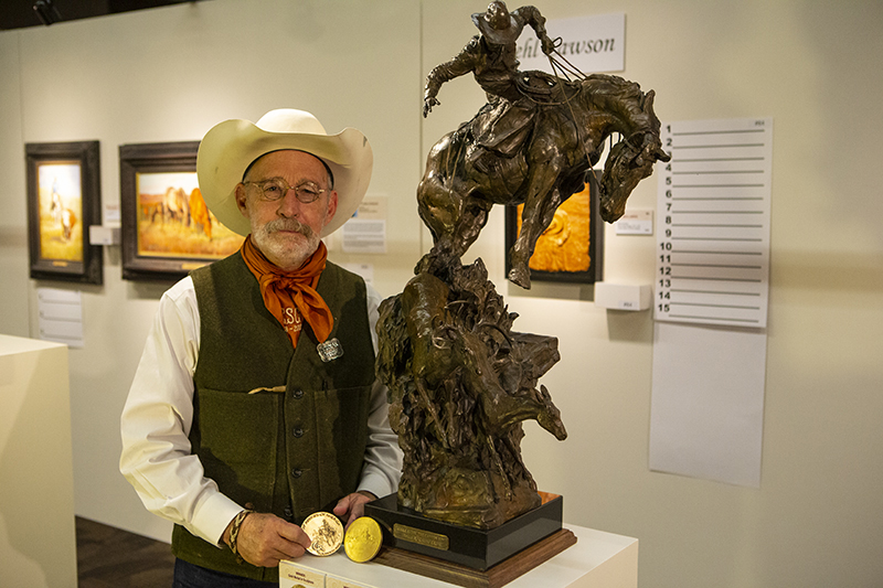 Cowboy sculpture Bruce Greene stands next to his piece at the annual CAA sale in Fort Worth, Texas.