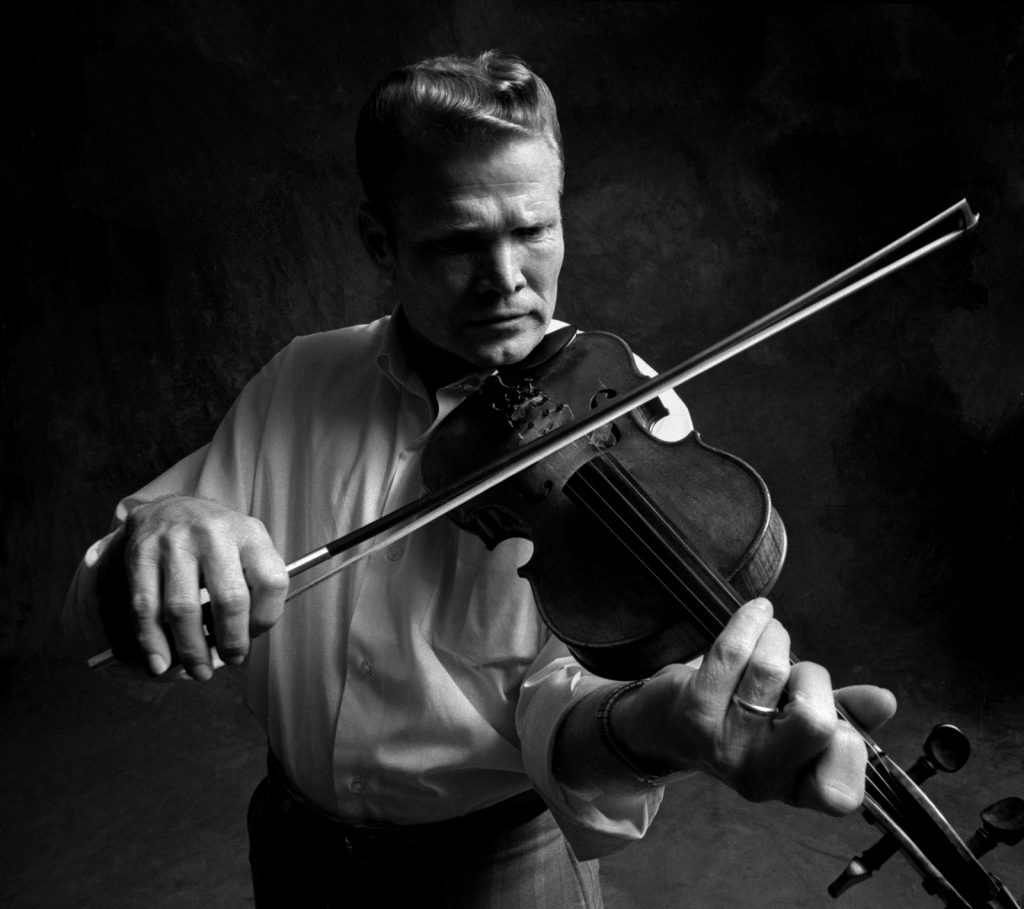 Vassar Clement plays the fiddle for a picture taken by McGuire.