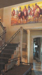 Western art painting hanging in a large open space.