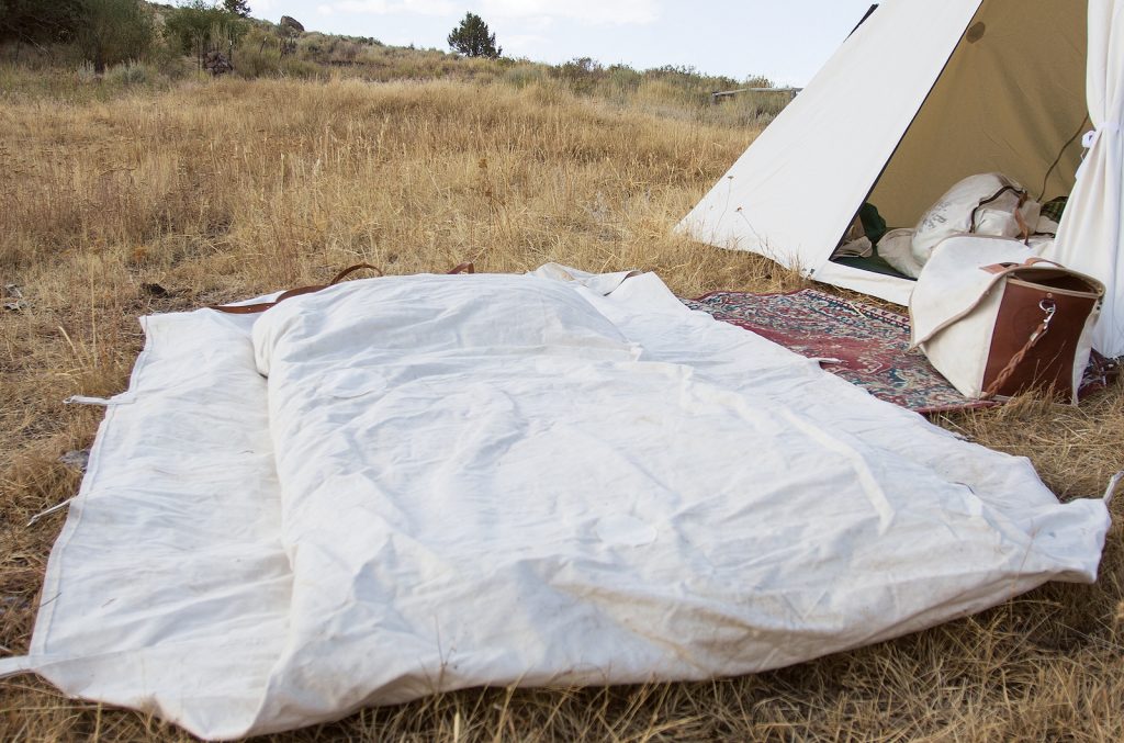 A cowboy's bedroll with the tarp tucked in on the sides.