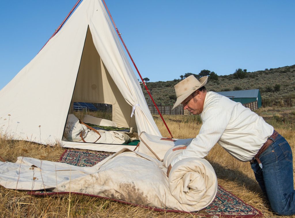 Rolling up the bedroll.