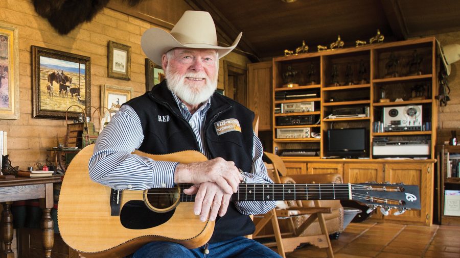 Red Steagall sits with his guitar.