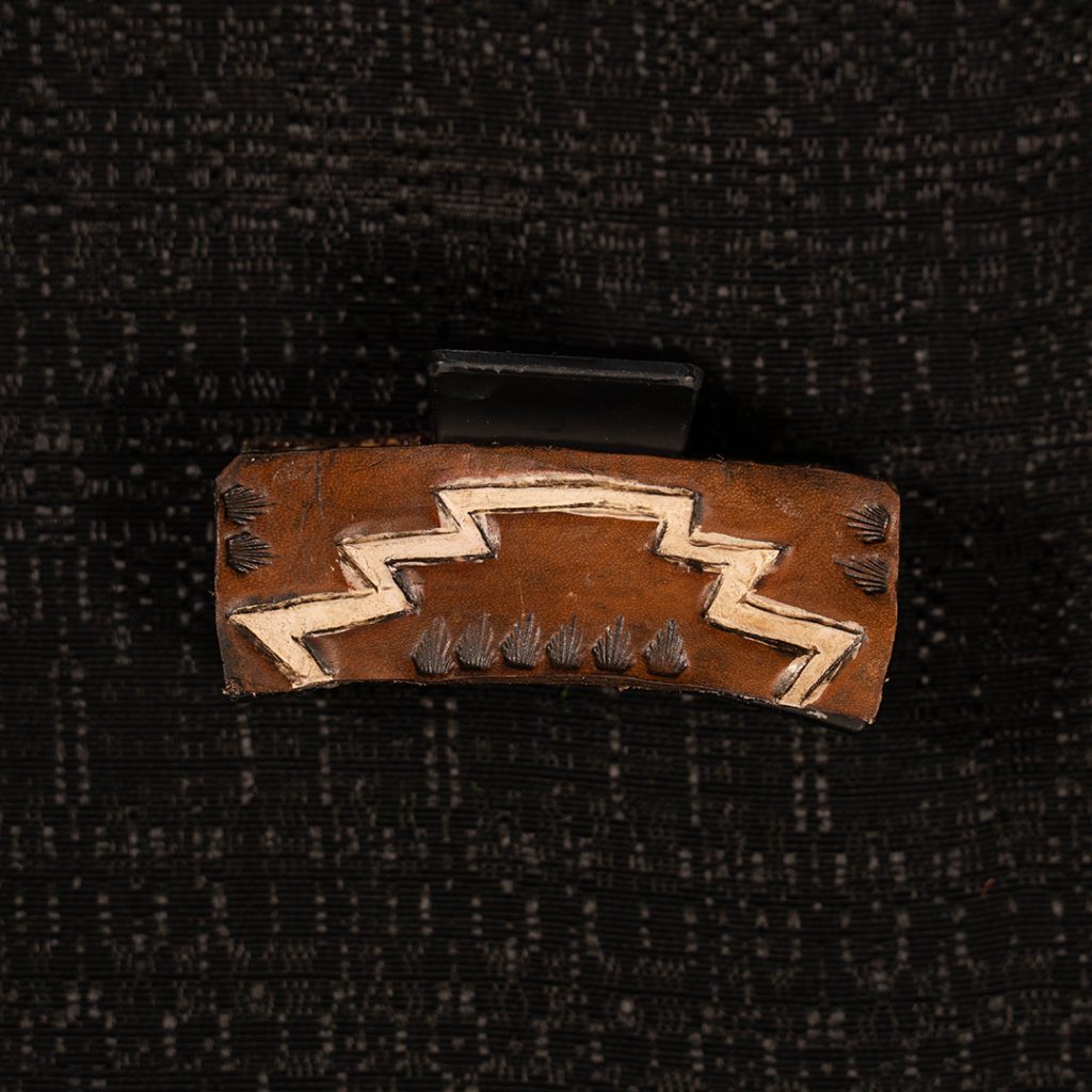 Tooled hair clip on black background.
