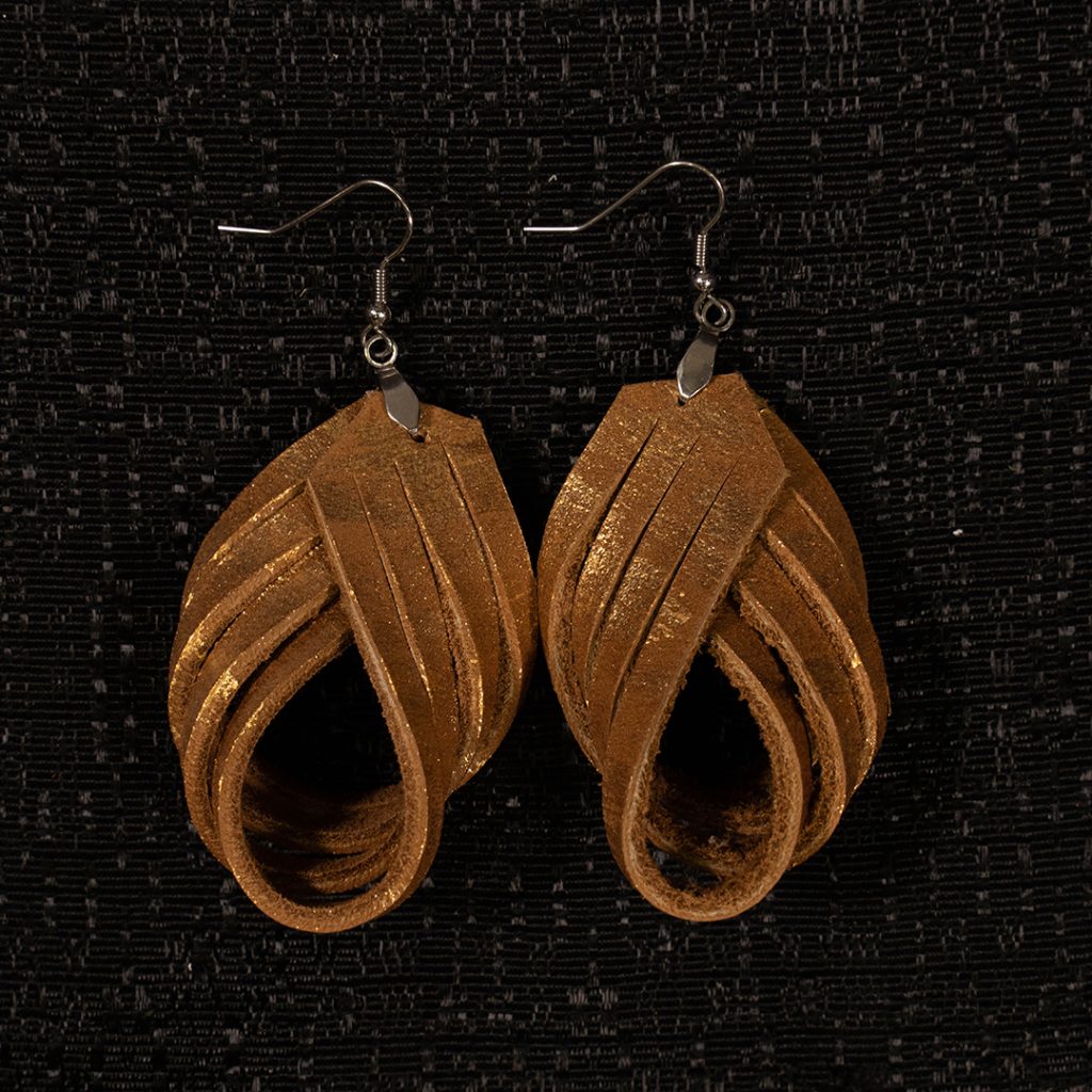 Leather earrings on black background.