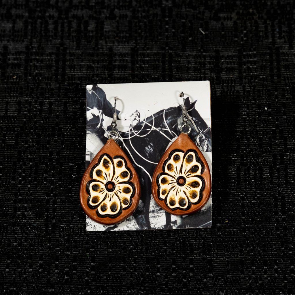 Tooled earrings on black background.