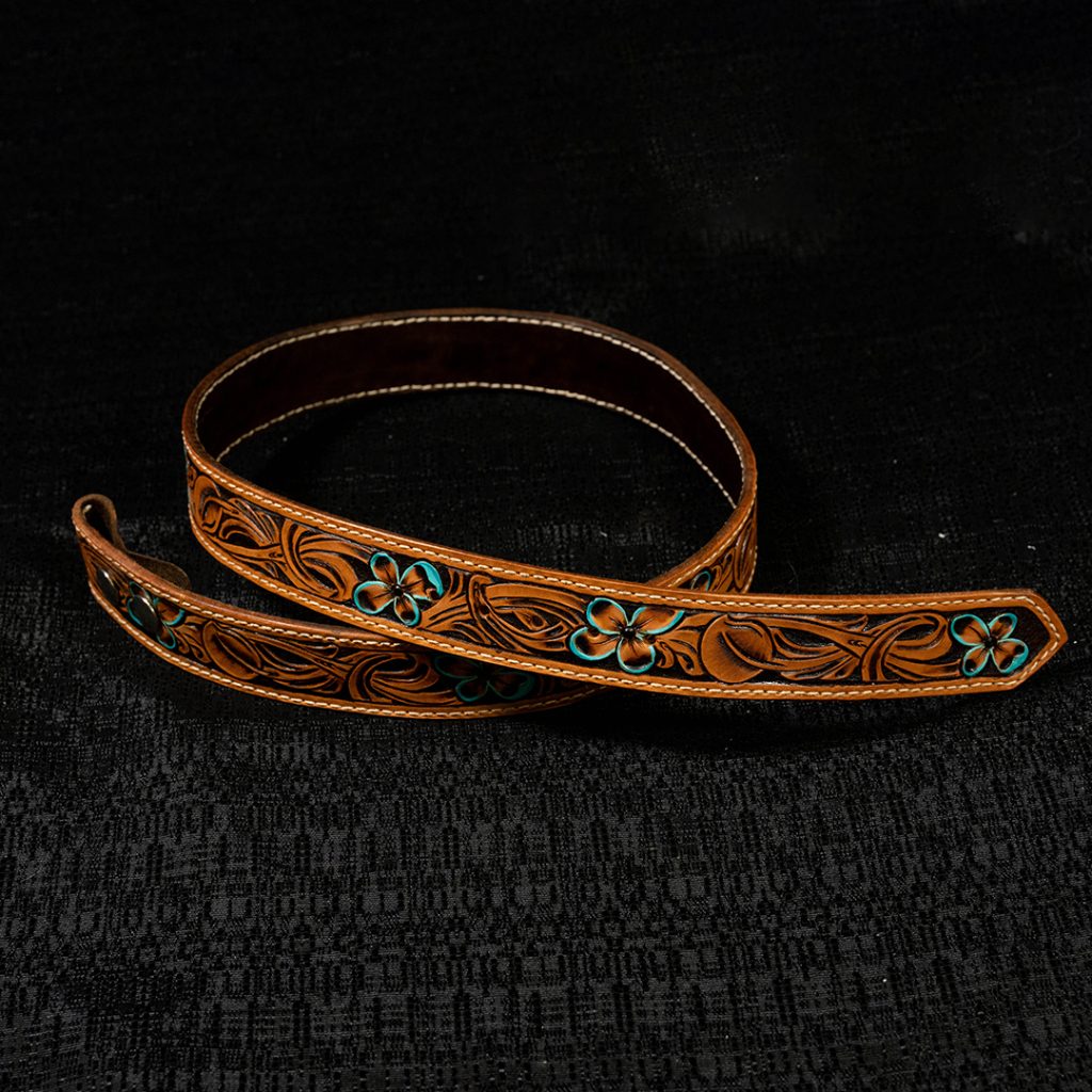 A tooled belt on a black background for the 2023 Western Lifestyle Trade Craft Showcase.
