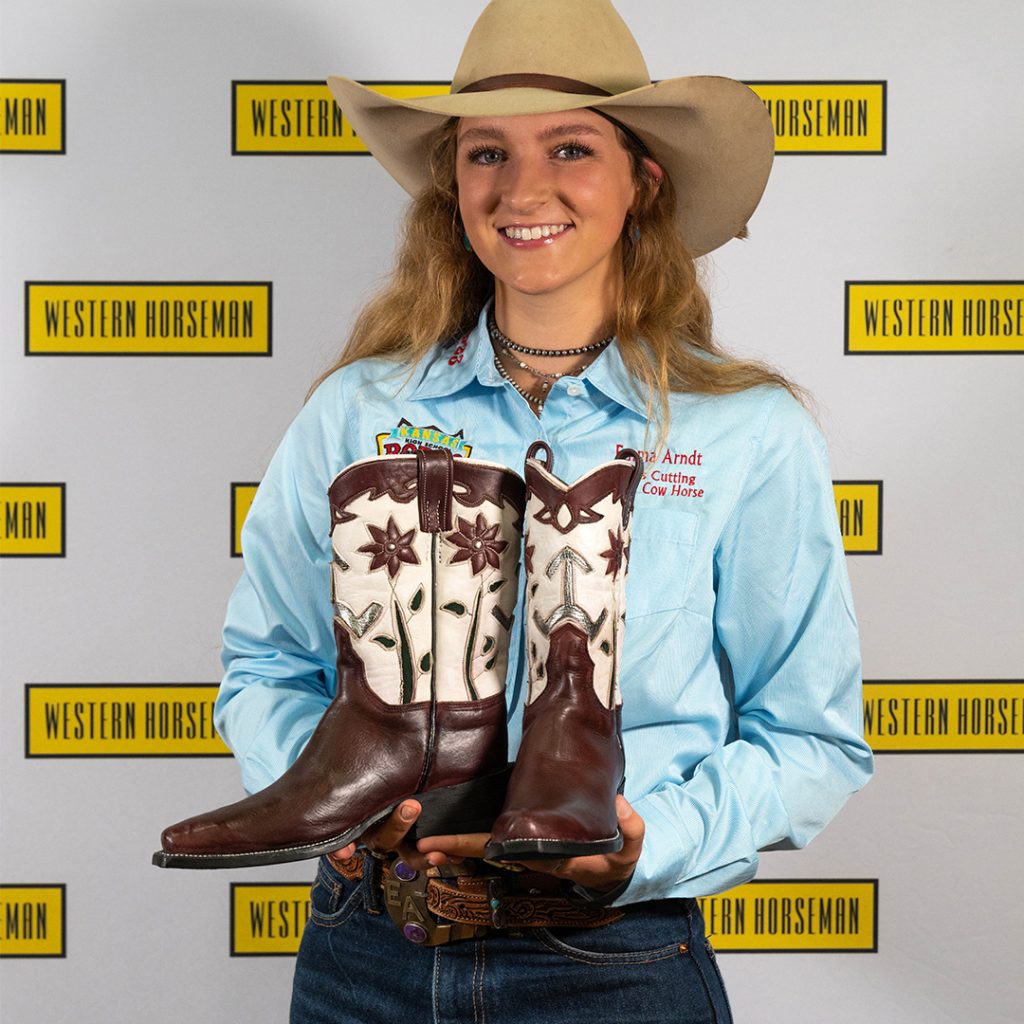 Emma Ardnt holding her handmade boots.