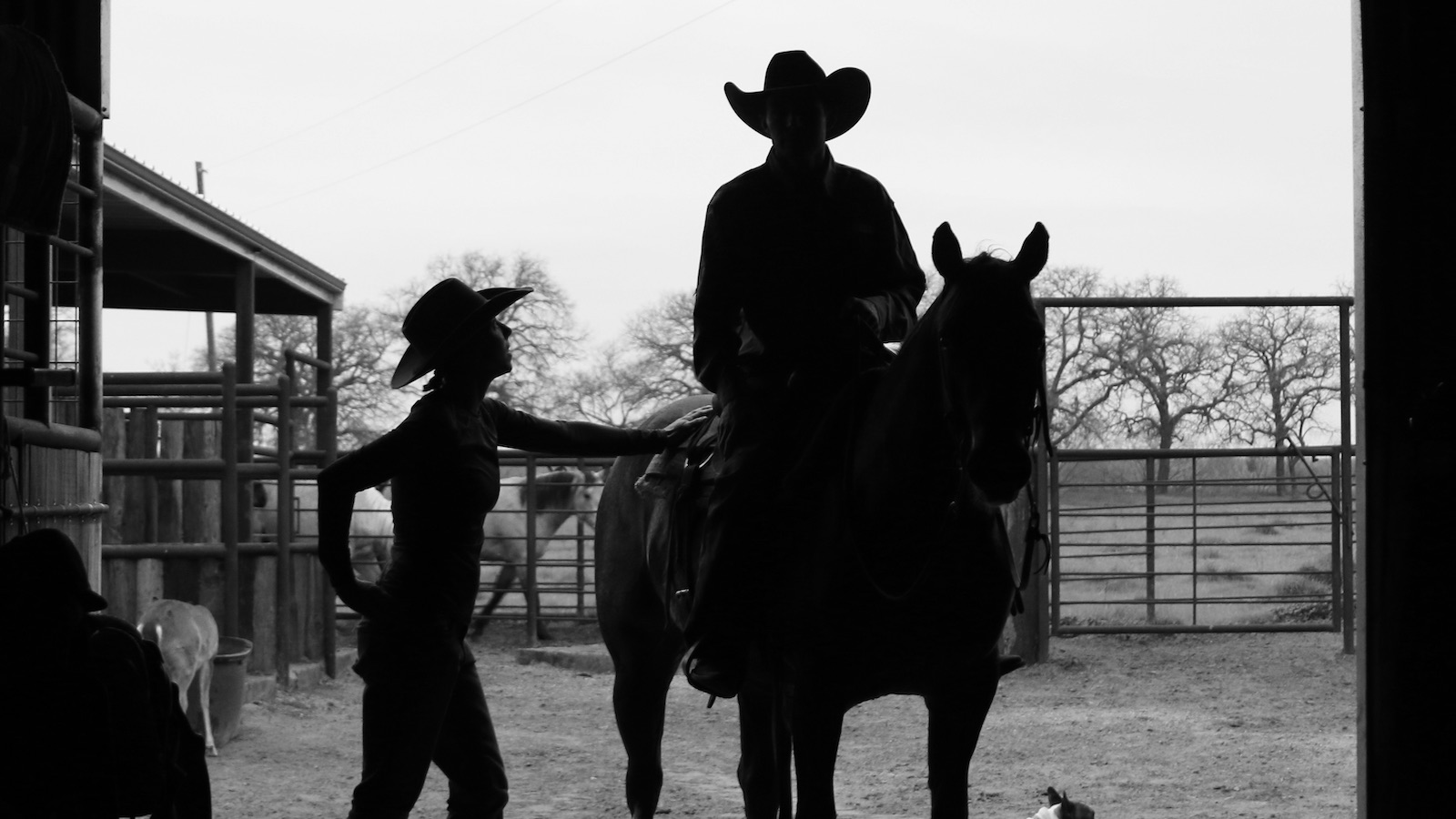 Man sitting on his horse and talking to his wife on the ground