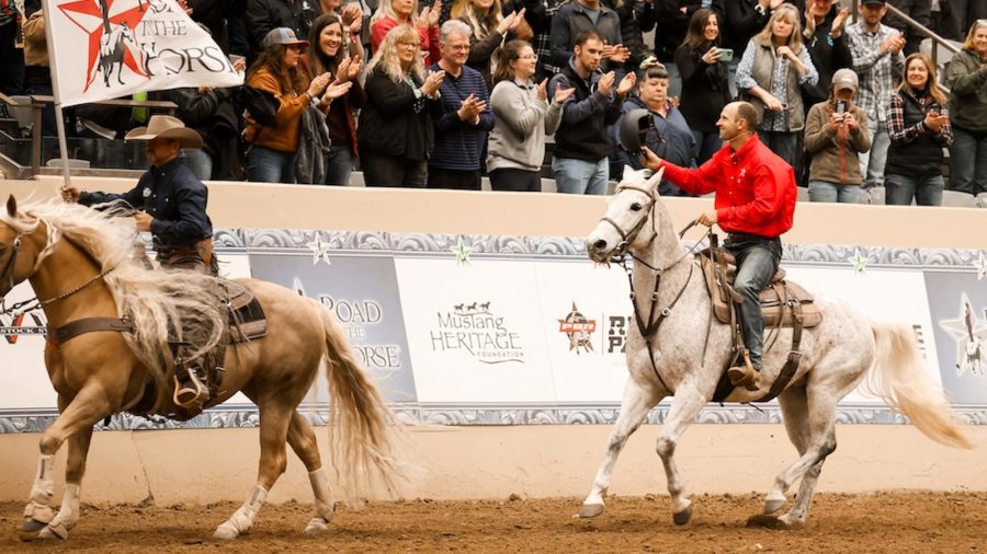 Tik Maynard rides a horse waving to the crowd.