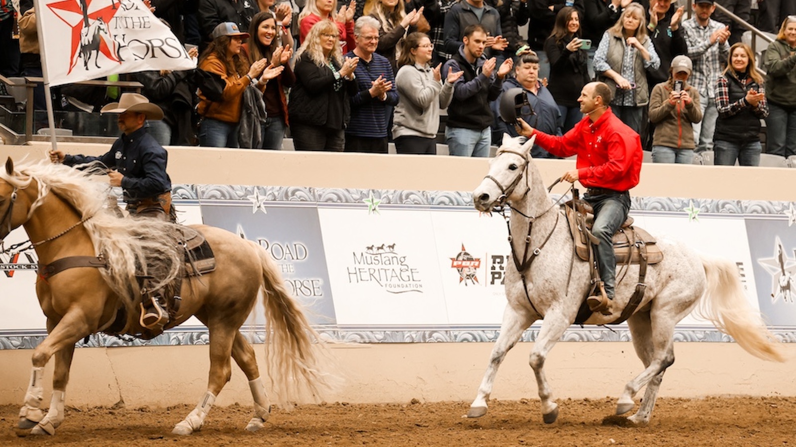 Tik Maynard rides a horse waving to the crowd.