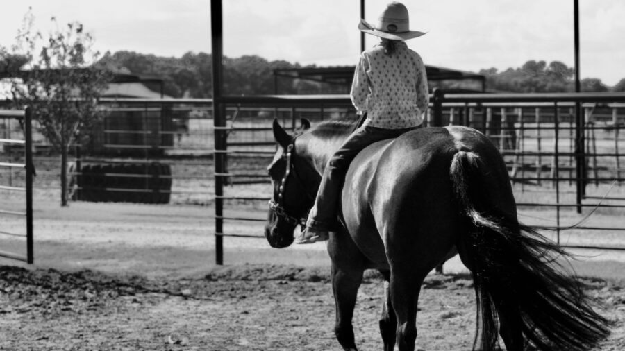 black and white image of a kid on a horse